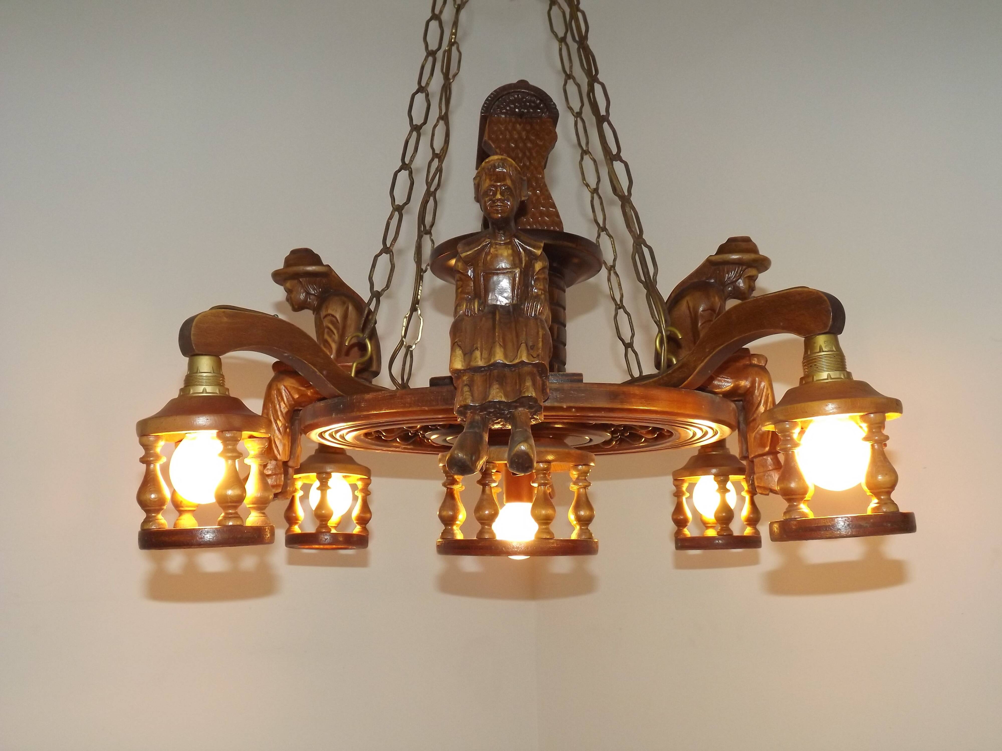 French vintage Breton chandelier with hand-carved figures, well, and lantern lights.