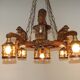 French vintage Breton chandelier with hand-carved figures, well, and lantern lights.