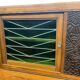 Vintage Art Deco display cabinet in wood with green stained glass.