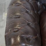 Old dark brown 3-seater cowhide chesterfield sofa with lots of character