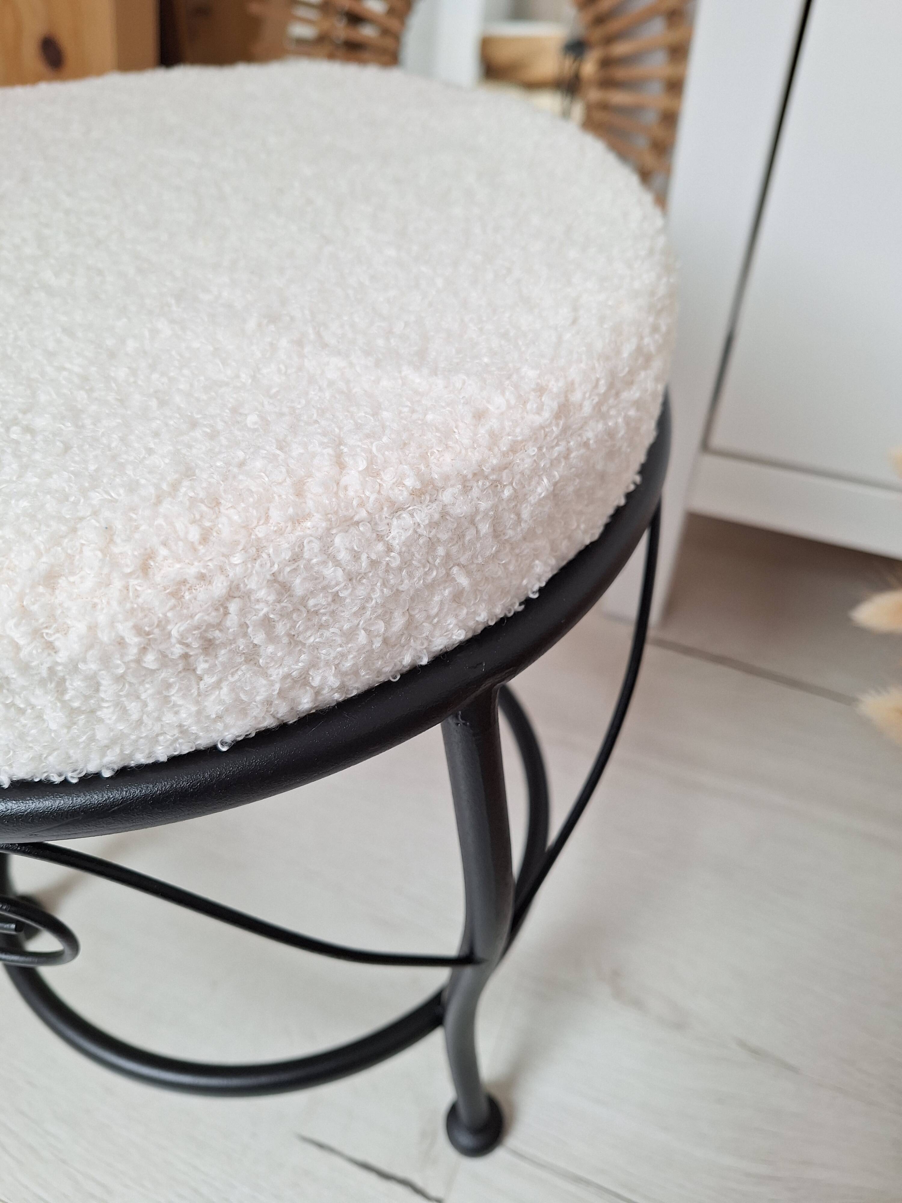 Black iron stool/pouf with its boucle fabric cushion.