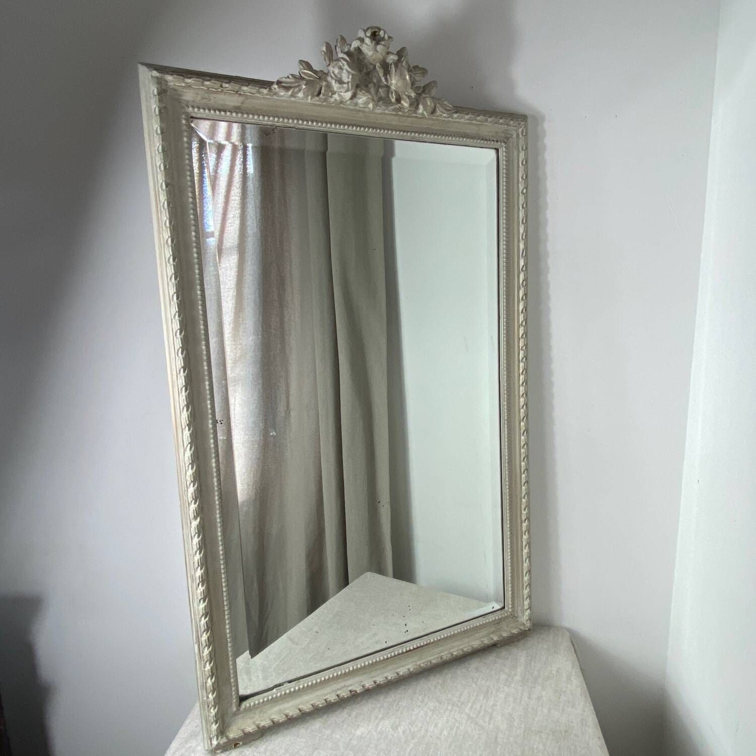 Large antique beveled mirror in carved wood painted with floral decoration and