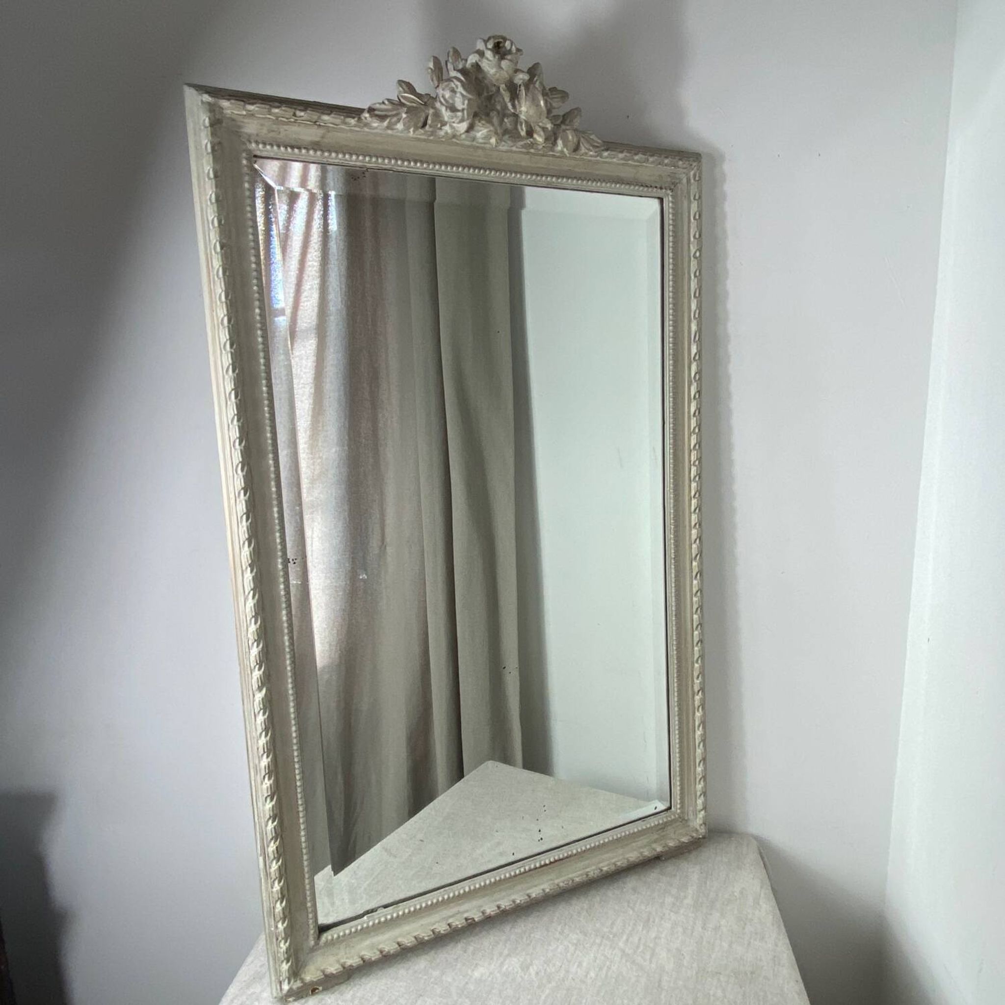 Large antique beveled mirror in carved wood painted with floral decoration and