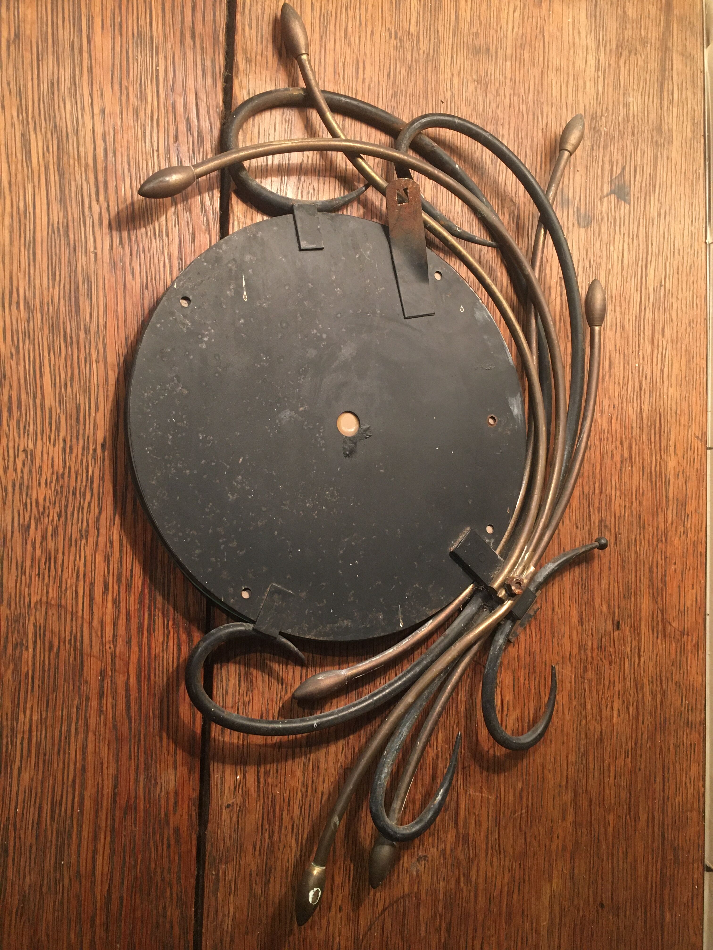 Round mirror surrounded by art deco style metal plants