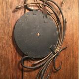 Round mirror surrounded by art deco style metal plants