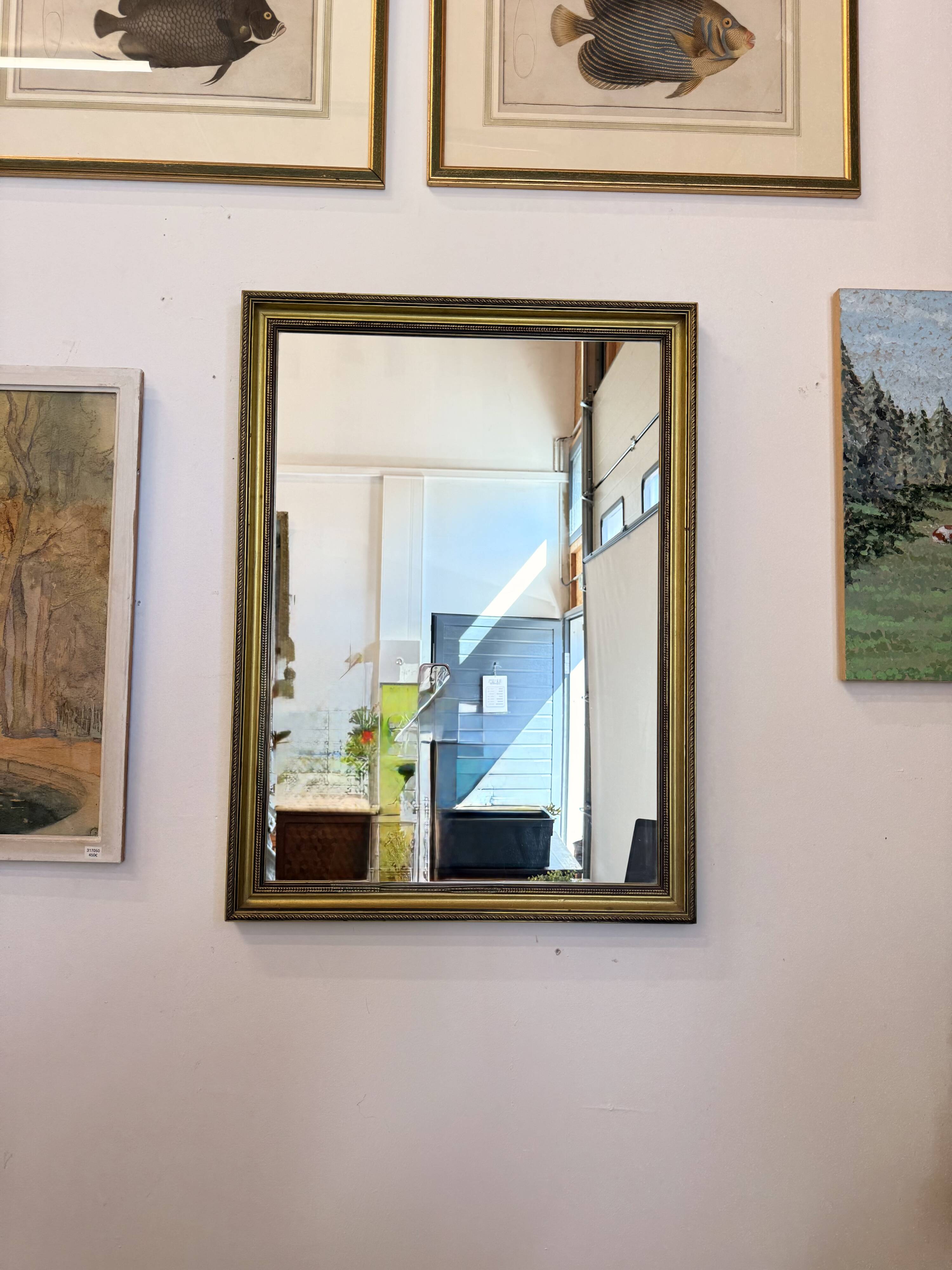 Vintage rectangular wall mirror with a golden wooden frame.