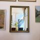 Vintage rectangular wall mirror with a golden wooden frame.