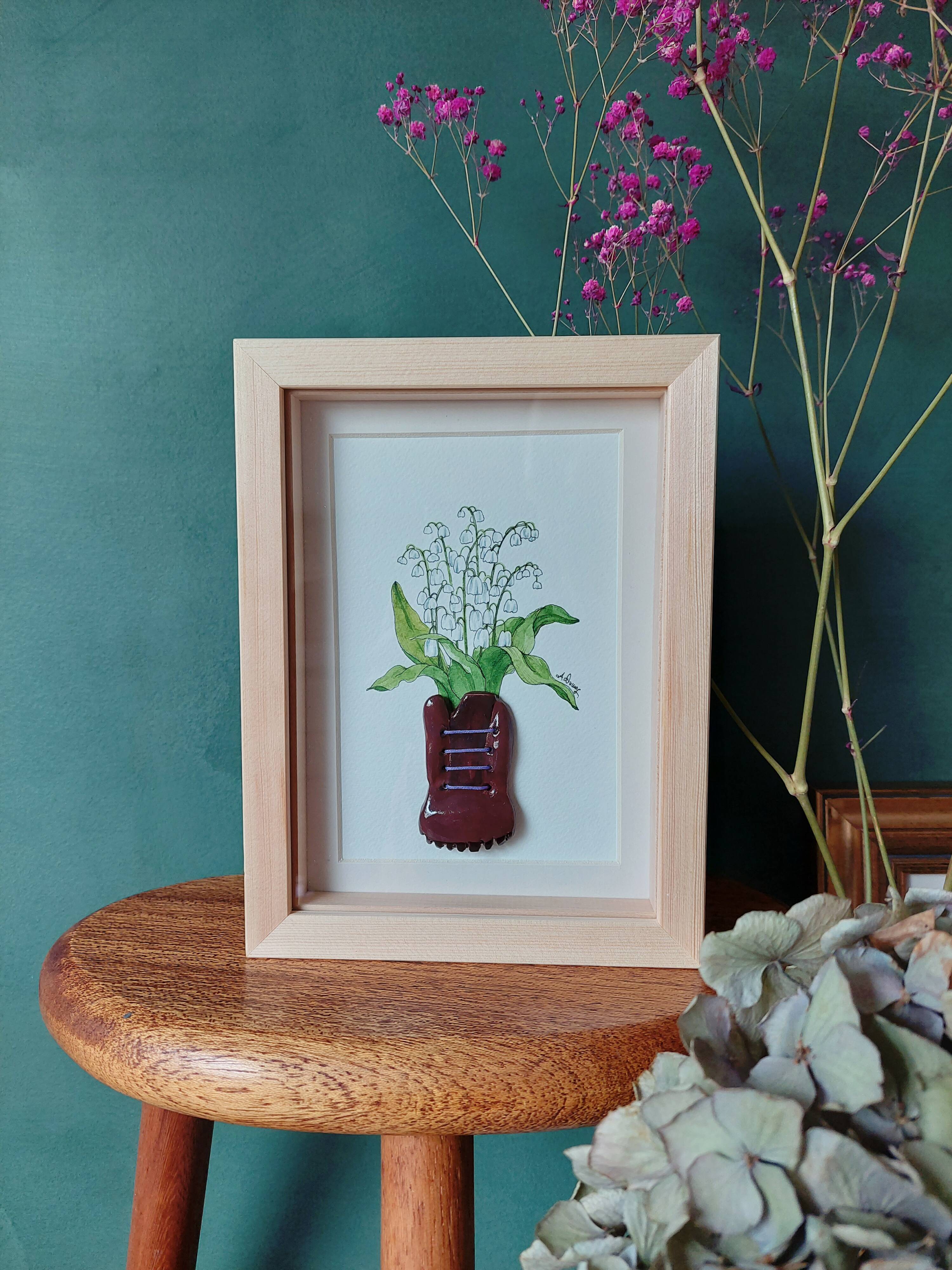 Composition of a bouquet of lilies of the valley in a shoe-shaped clay pot