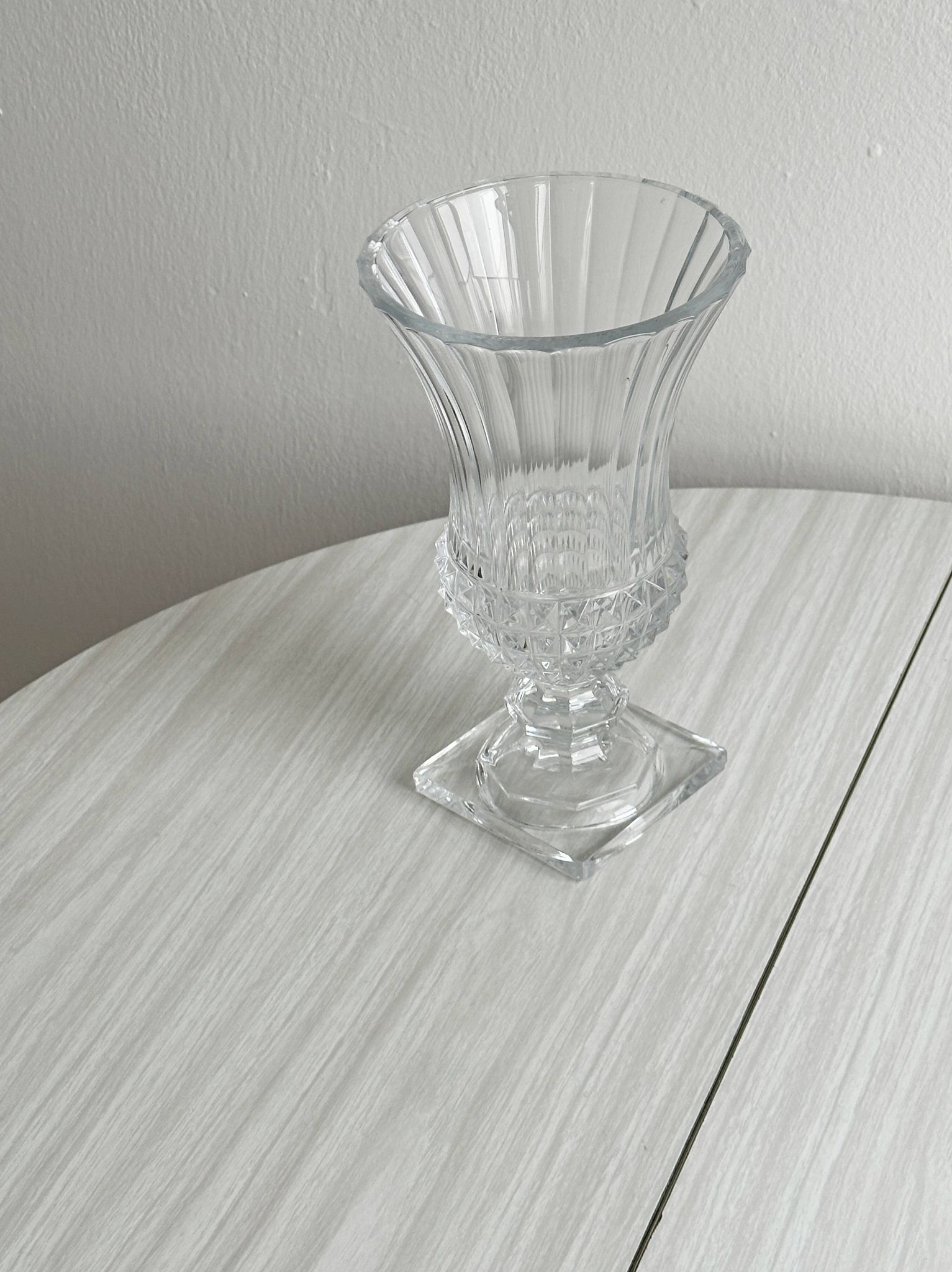 Antique thick glass vase on a pedestal.