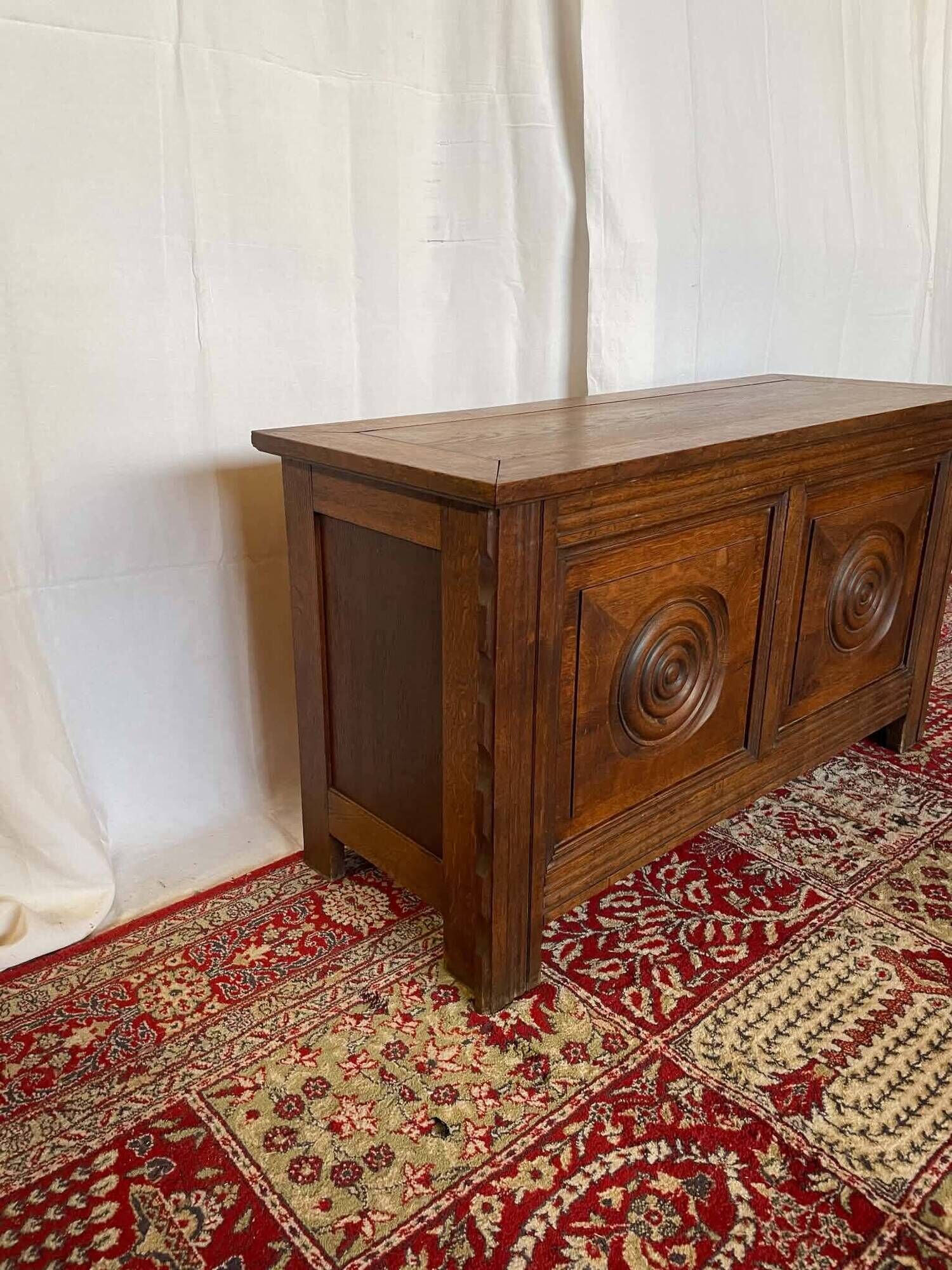 Small antique oak chest with carved panels.