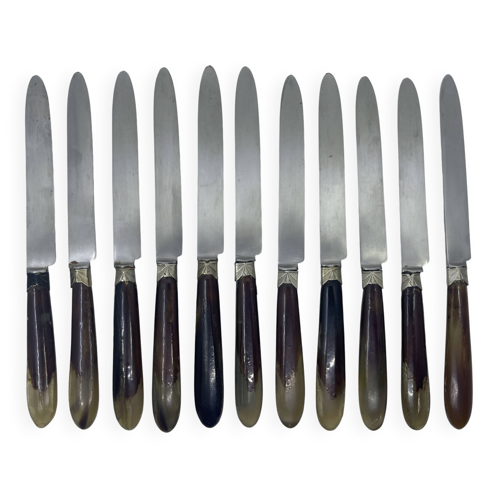 Set of 11 dessert knives with two-tone horn-effect resin handles.