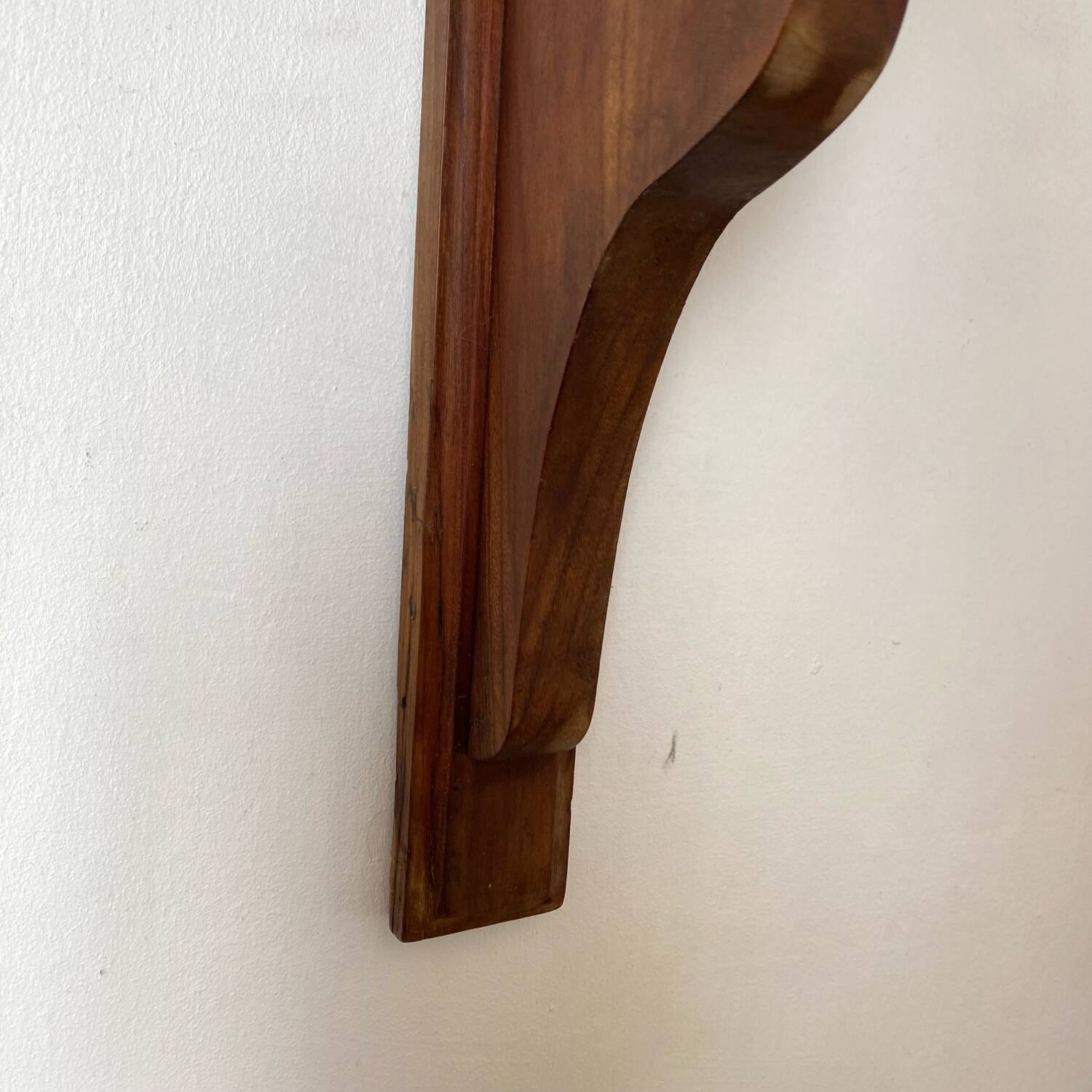 Antique wall shelf with a scalloped edge.