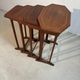 Four nesting tables with polygonal tops and decorative inlays.