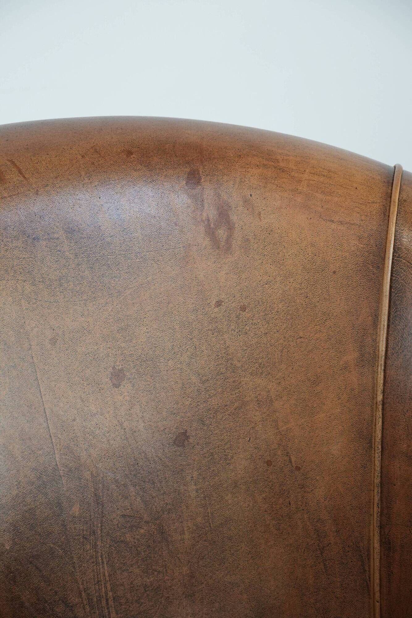 Club chair made of sheepskin leather finished with decorative nails