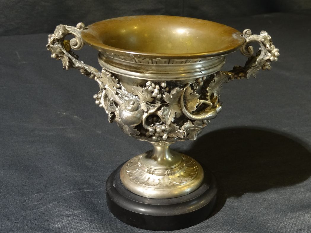 Carved silver bronze vase mounted on marble pedestal