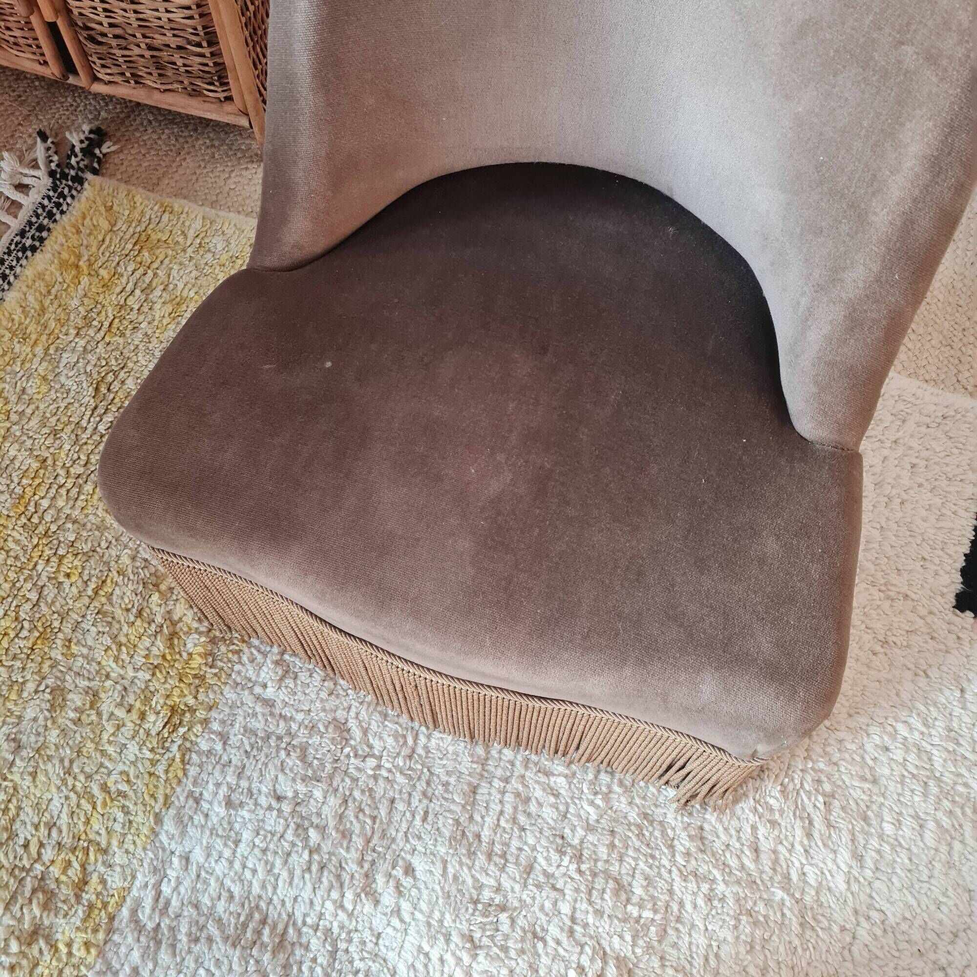 Brown velvet crapaud armchair with fringes and sculpted legs.