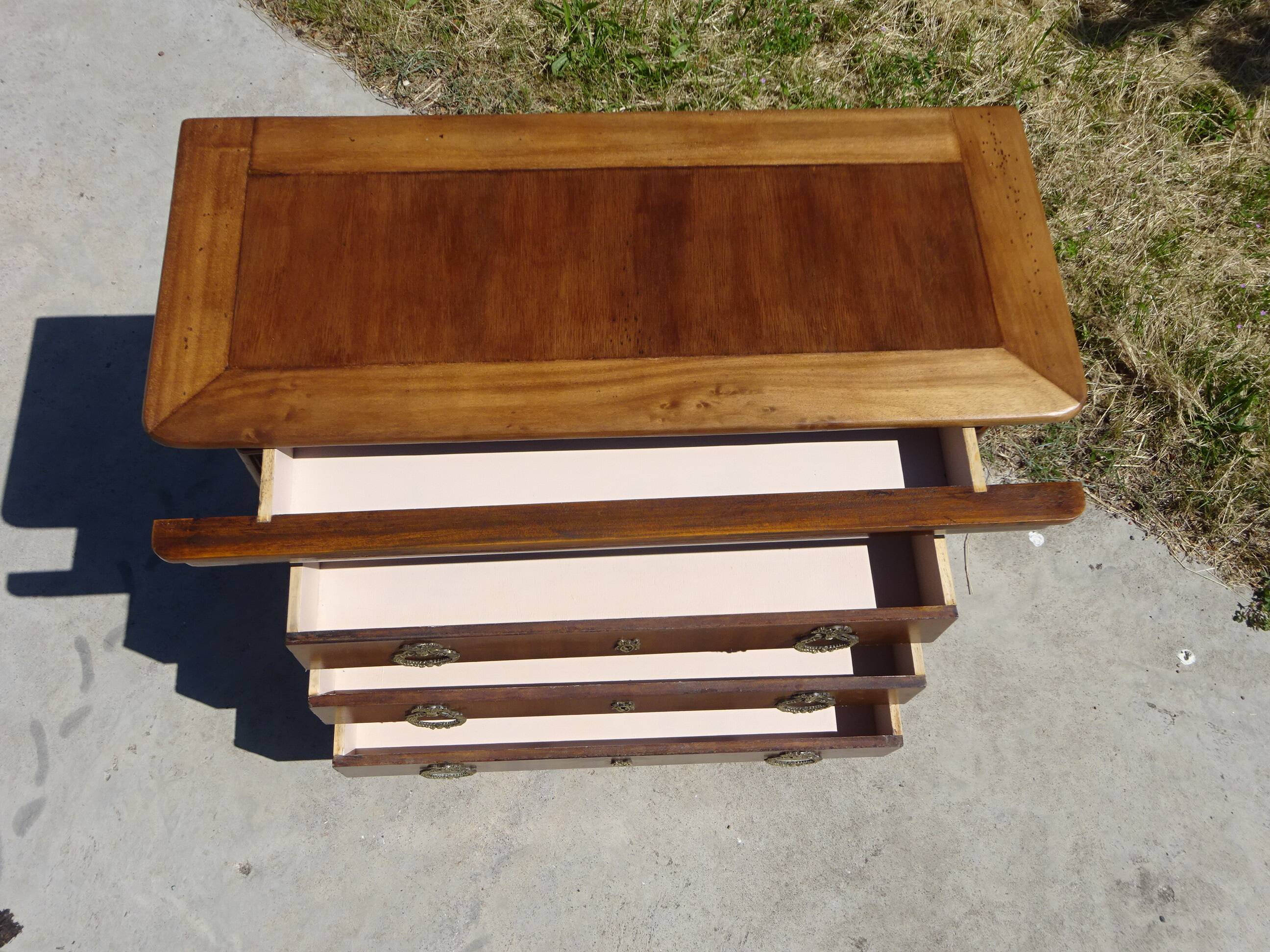 Chest of drawers with decorated handles in the Louis XVI style.