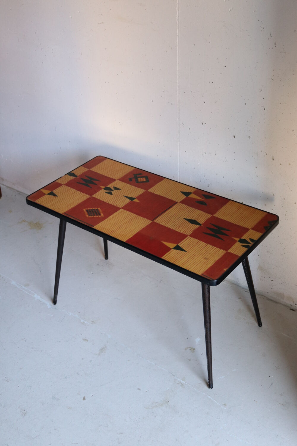 Vintage coffee table in laminate with geometric design, with tapered legs.