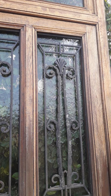 Oak entrance door and its frame and transom, wrought iron gates