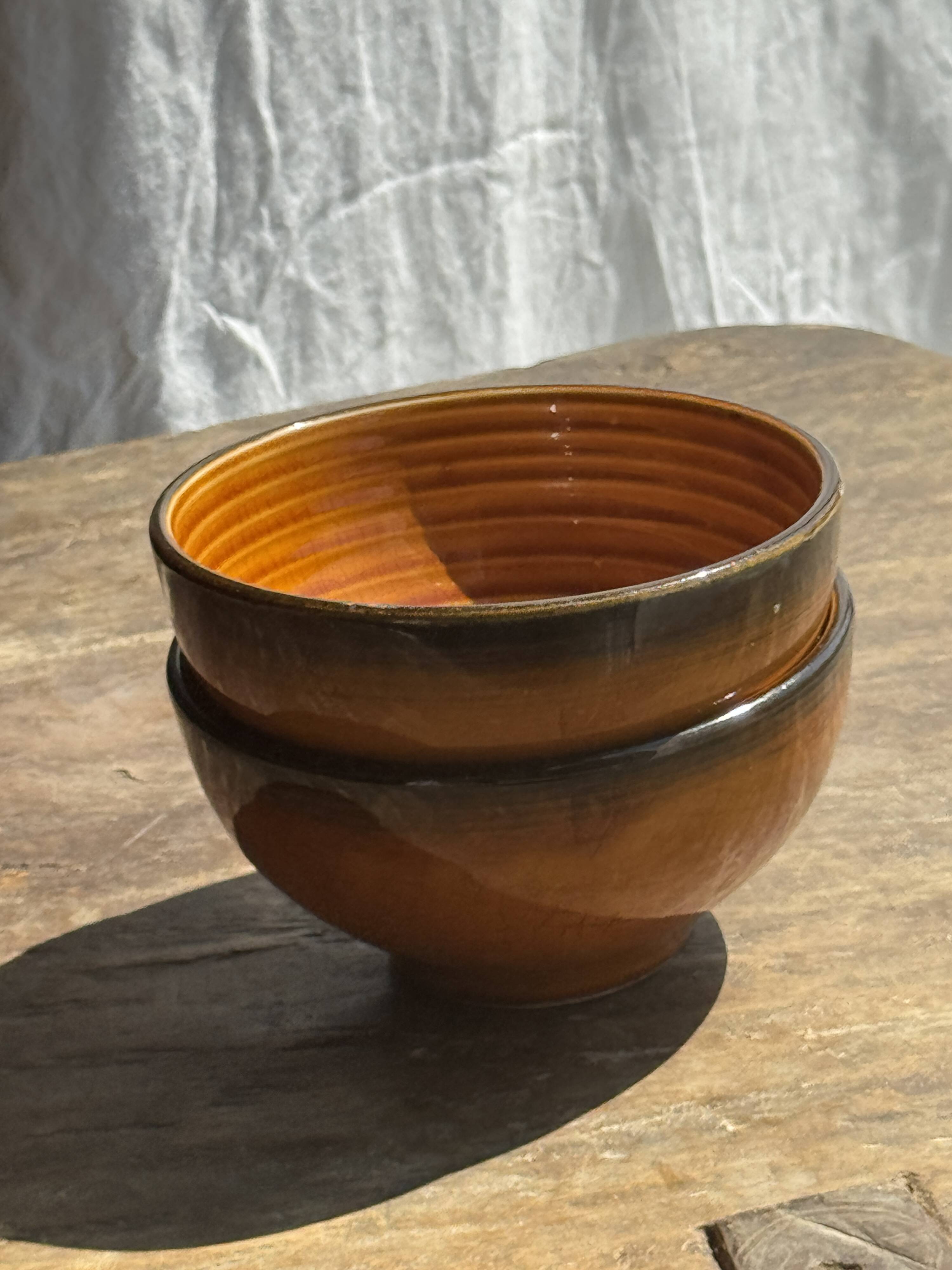Pair of small orange bowls with black edging
