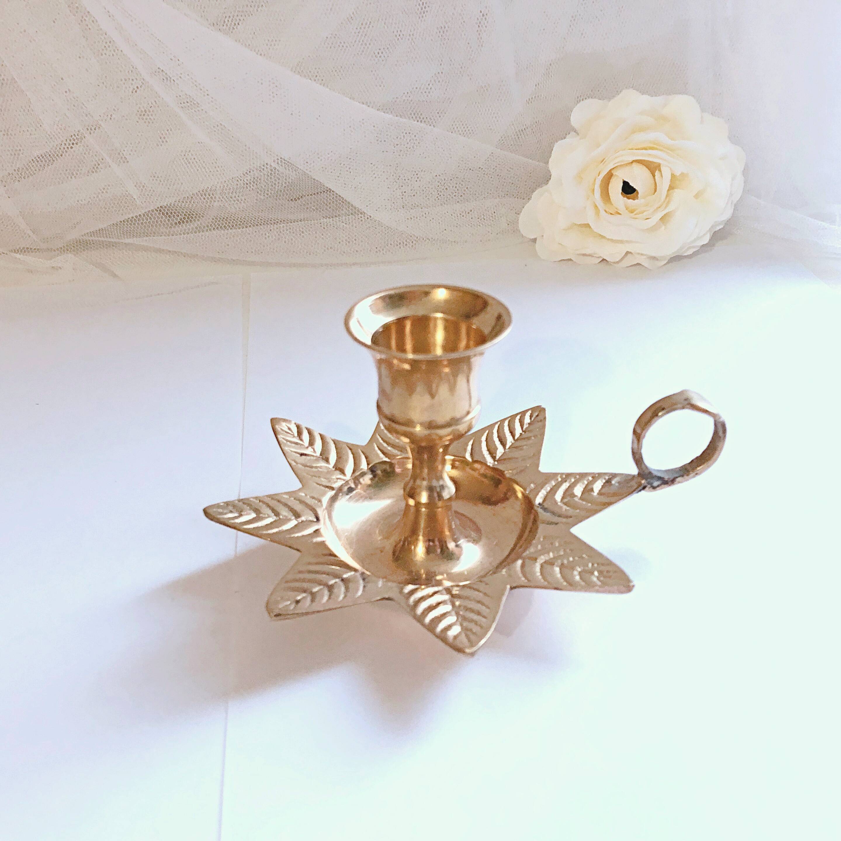Golden brass hand candle holder decorated with leaves