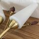Pair of wall sconces in brass with white glass tulips.