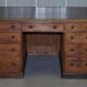 Antique Victorian oak kneehole desk with 18 double-sided drawers.