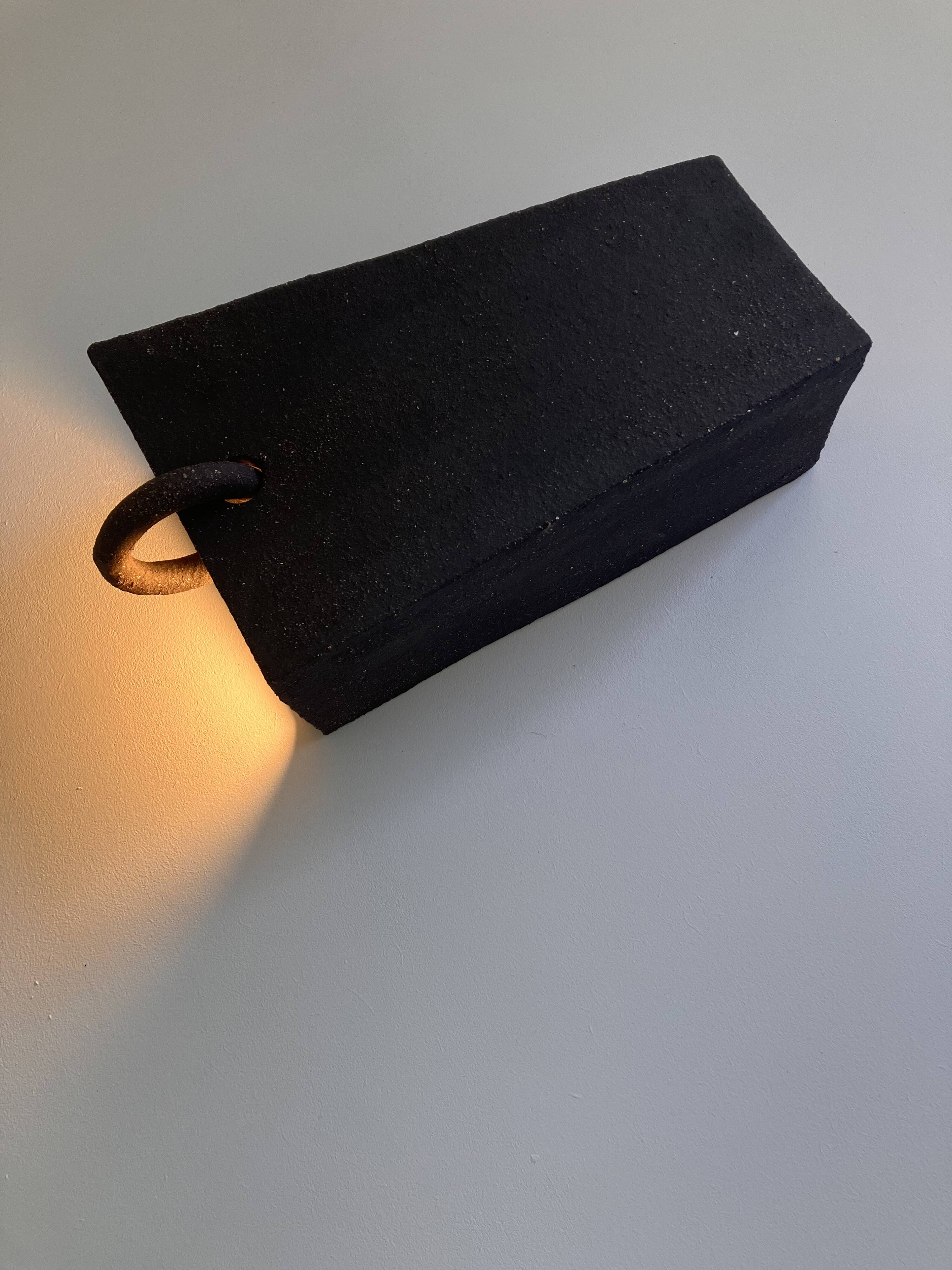 Pair of black stoneware graphic wall lights with handmade ring.
