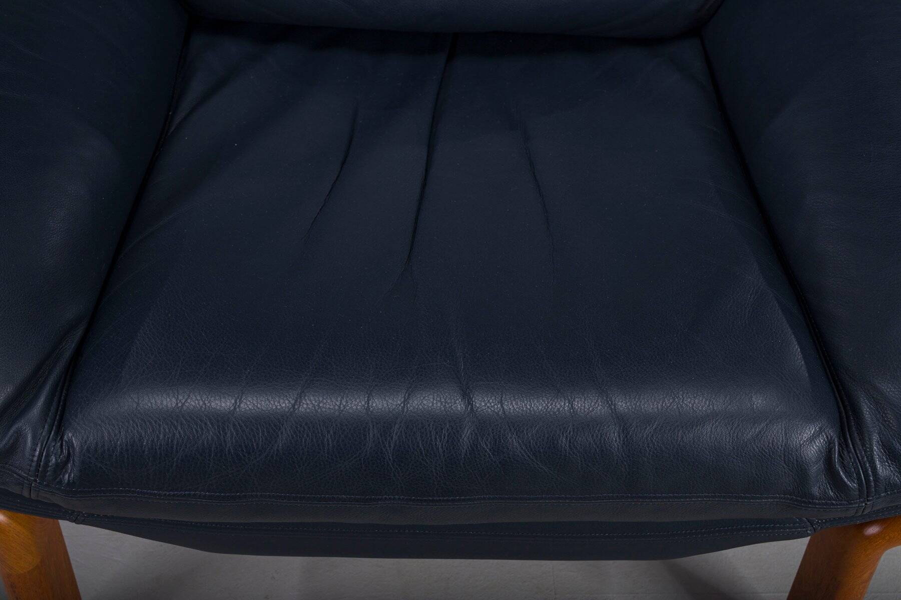 Danish teak and navy blue leather lounge chair from Komfort, 1970s