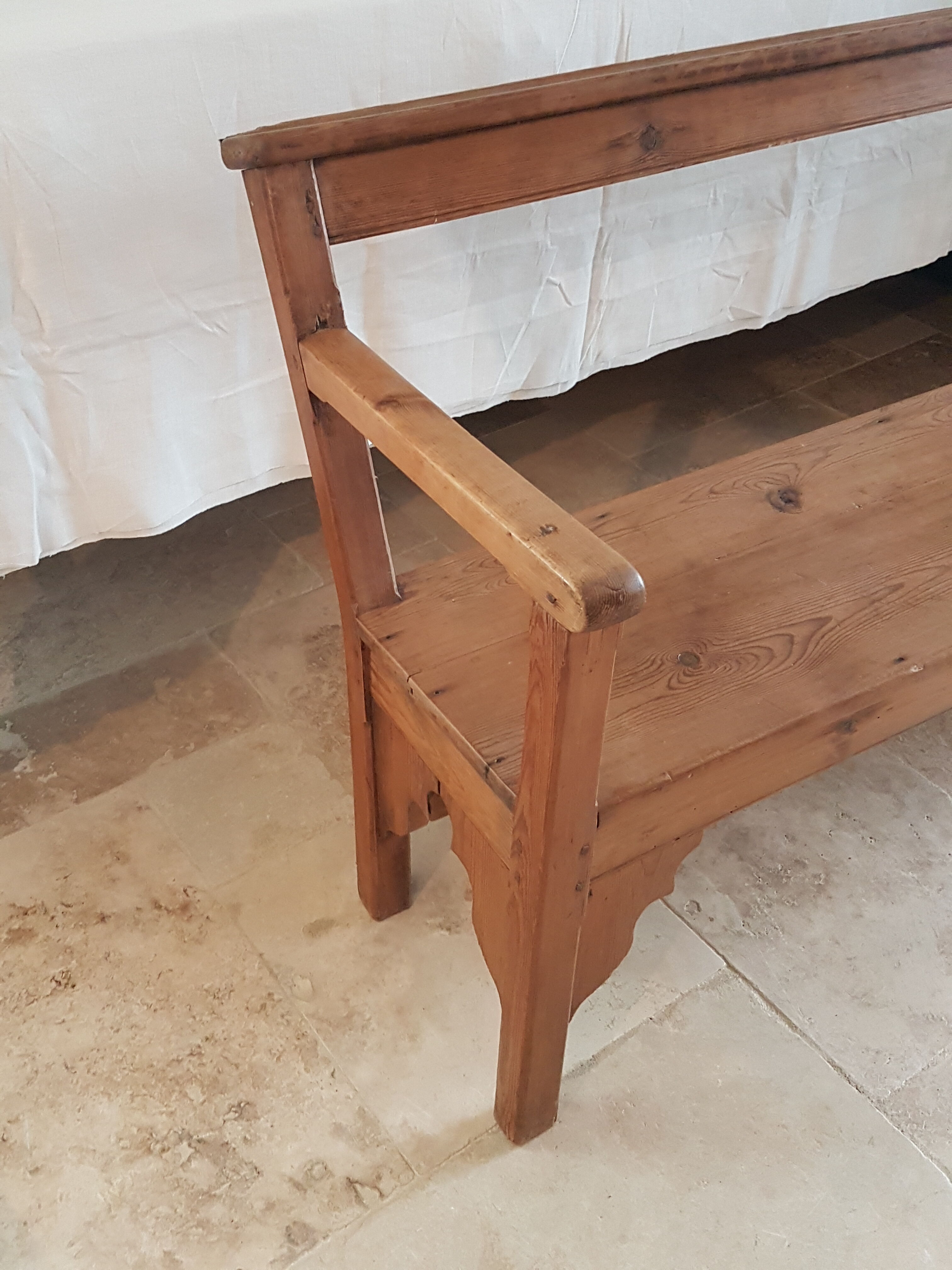 Church bench in fir tree with armrests