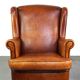 Fauteuil en cuir de mouton subtil et bien entretenu sur roulettes avant en laiton