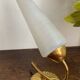 Gold metal wall light with ribbed glass.
