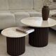 Round nesting coffee table in travertine and dark fluted wood.