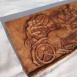 Bas-relief plaster scene of horses and a cart.