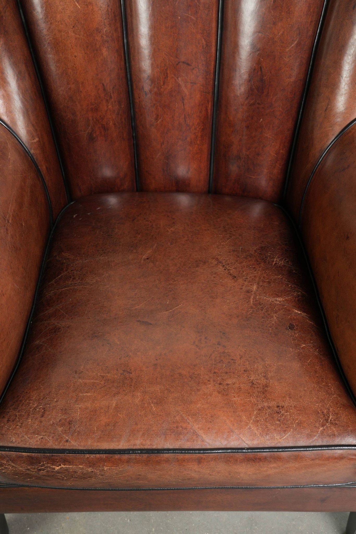 Unique sheepskin armchair with warm deep colours finished with black piping