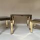 Set of three nesting side tables in brass and smoked mirror.