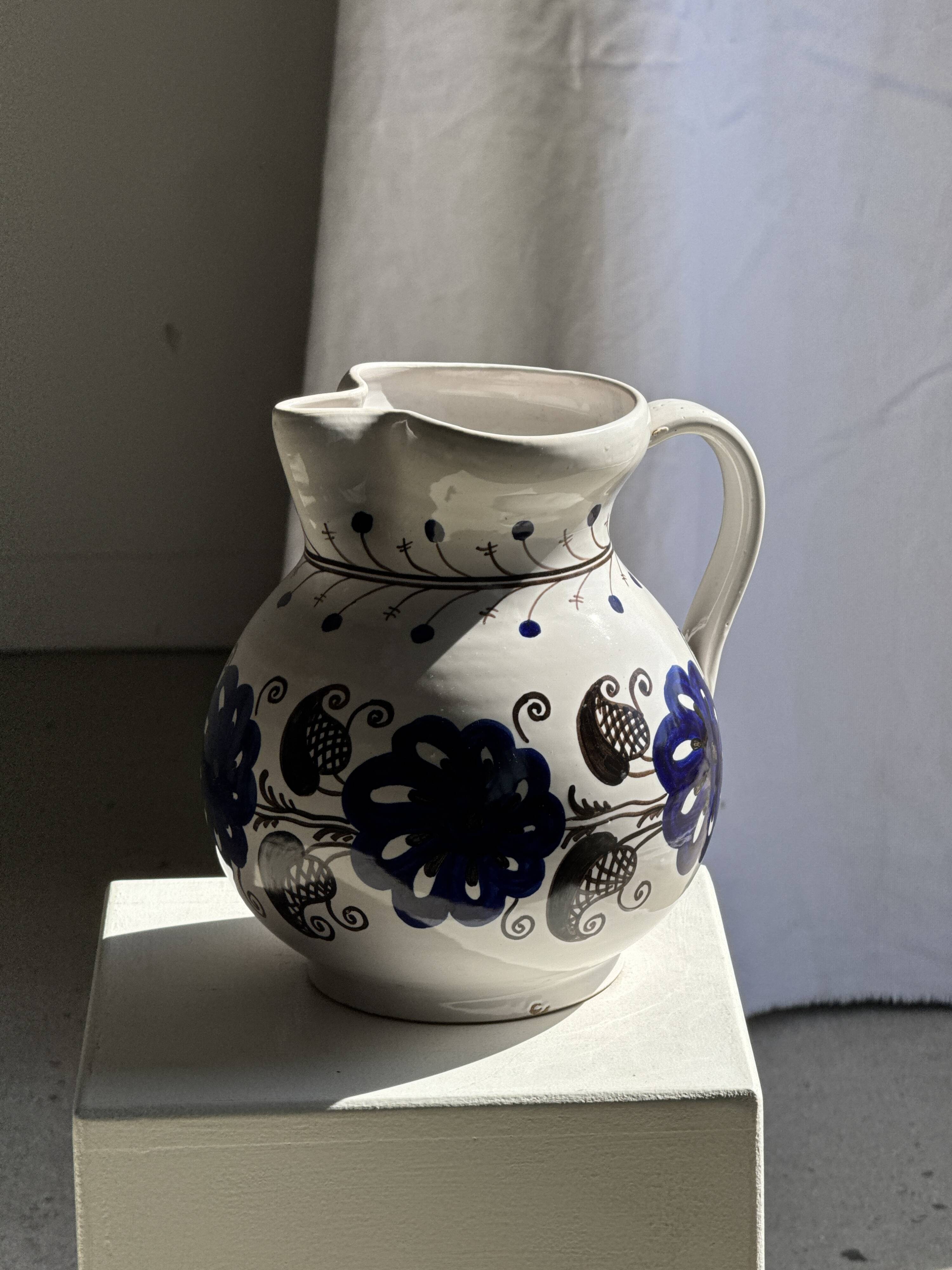 Very large vintage ceramic carafe in white glazed with blue floral decoration.