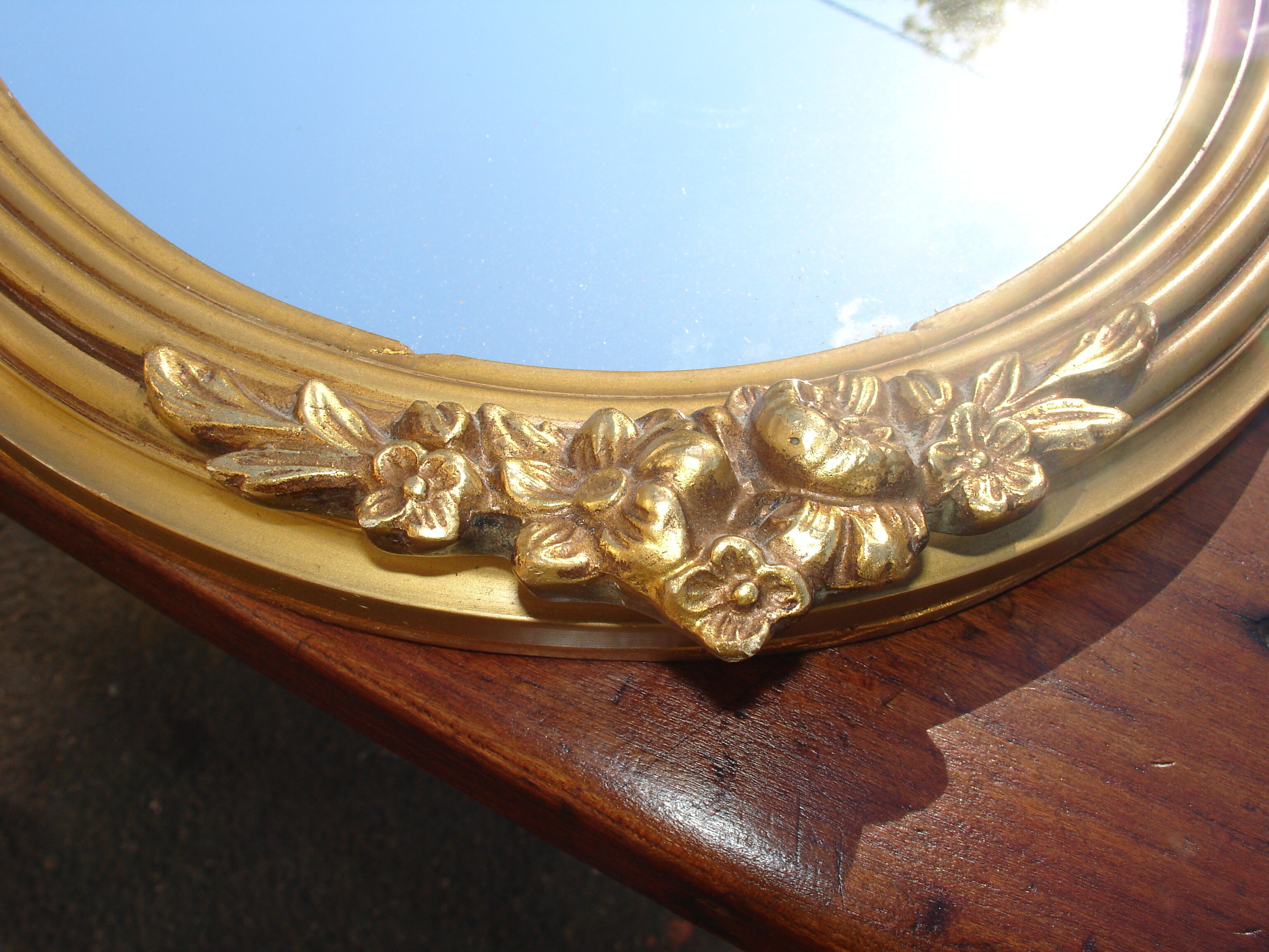 Oval gilt mirror, 30 x 44 cm, with floral decoration, circa 1930