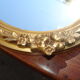 Oval gilt mirror, 30 x 44 cm, with floral decoration, circa 1930