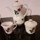 White porcelain coffee service of 3 pieces with a rose design.