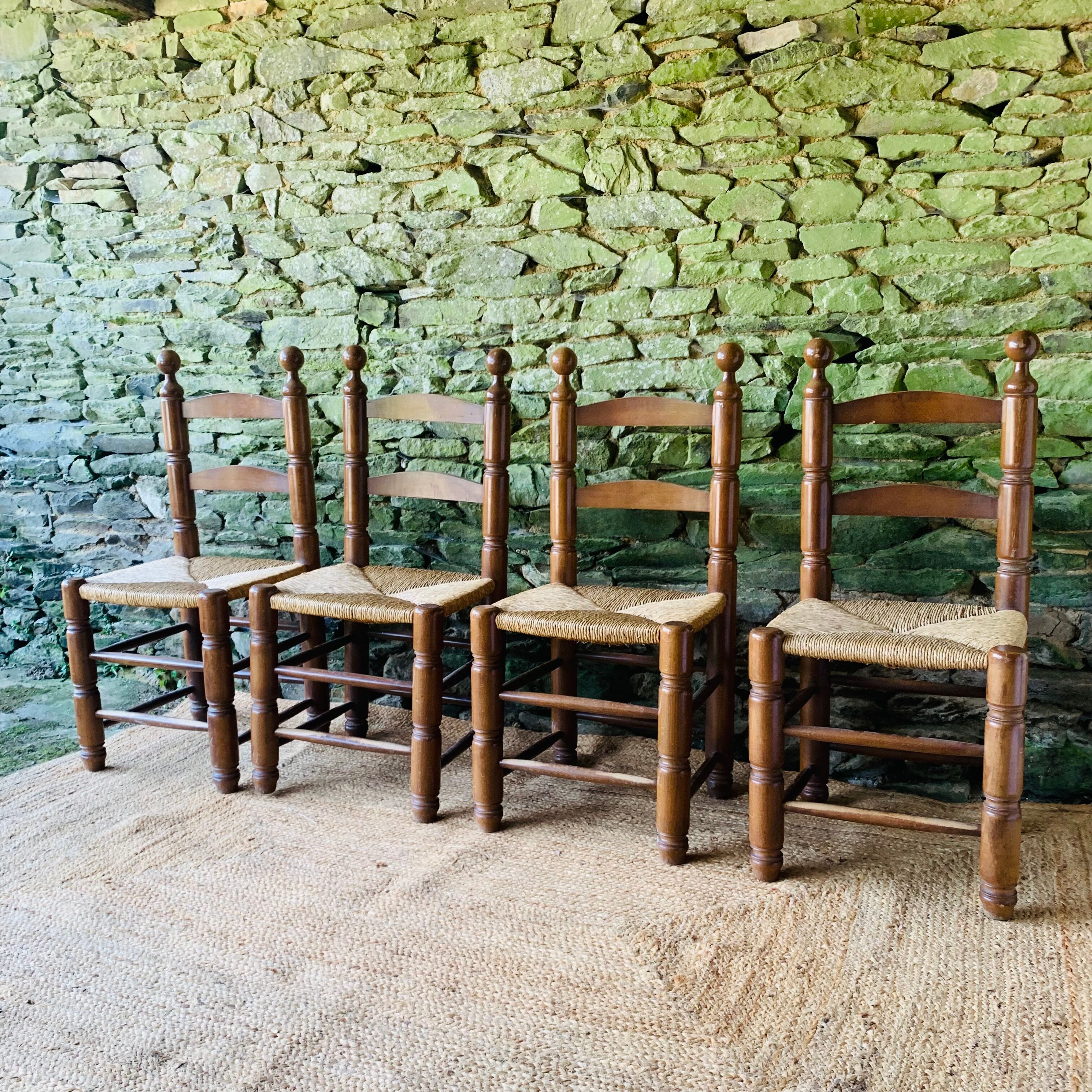 Set of 4 solid wood chairs with straw seats.