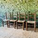Set of 4 solid wood chairs with straw seats.