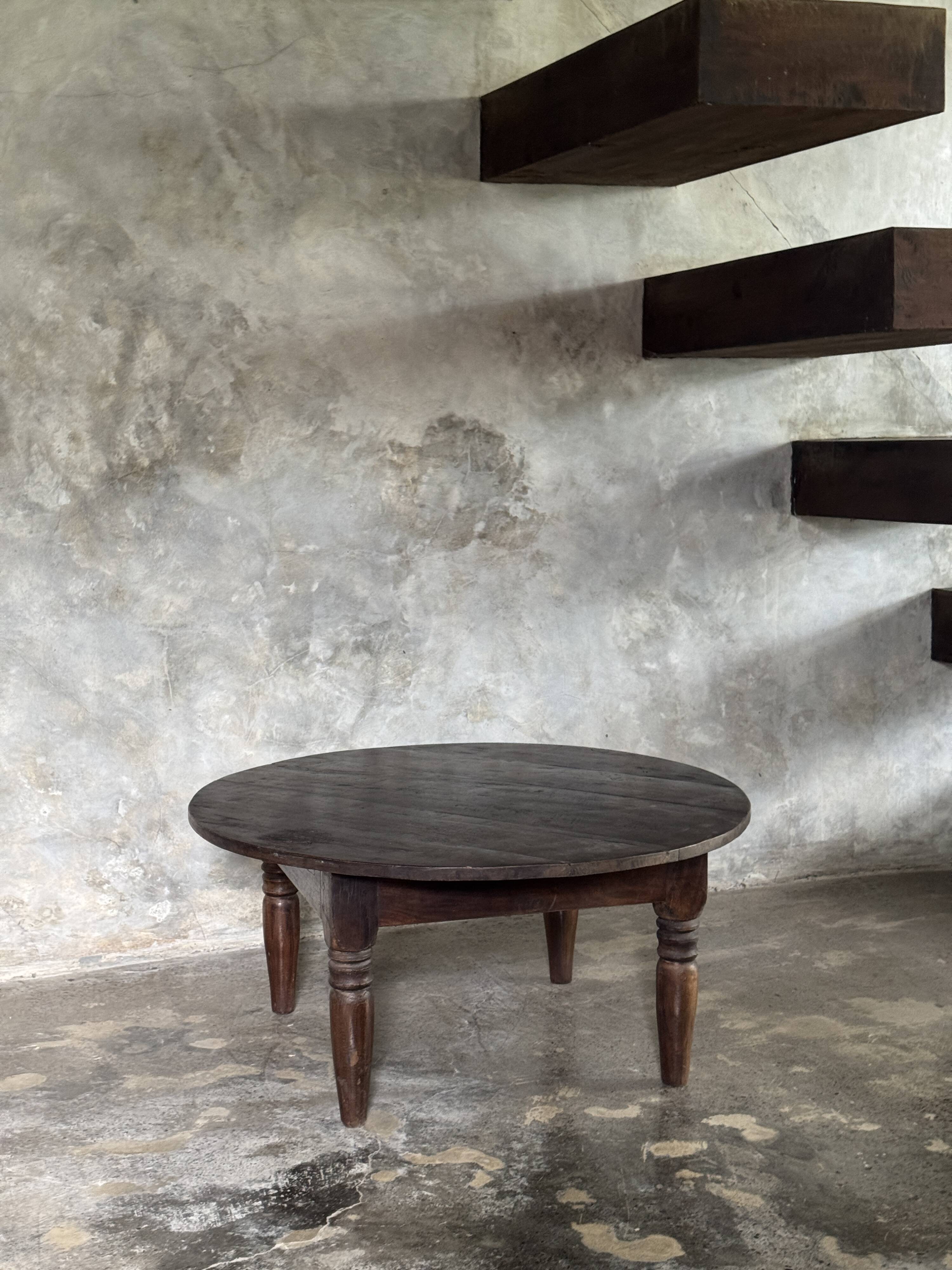 Coffee table, round antique Indonesian teak table with straight legs.