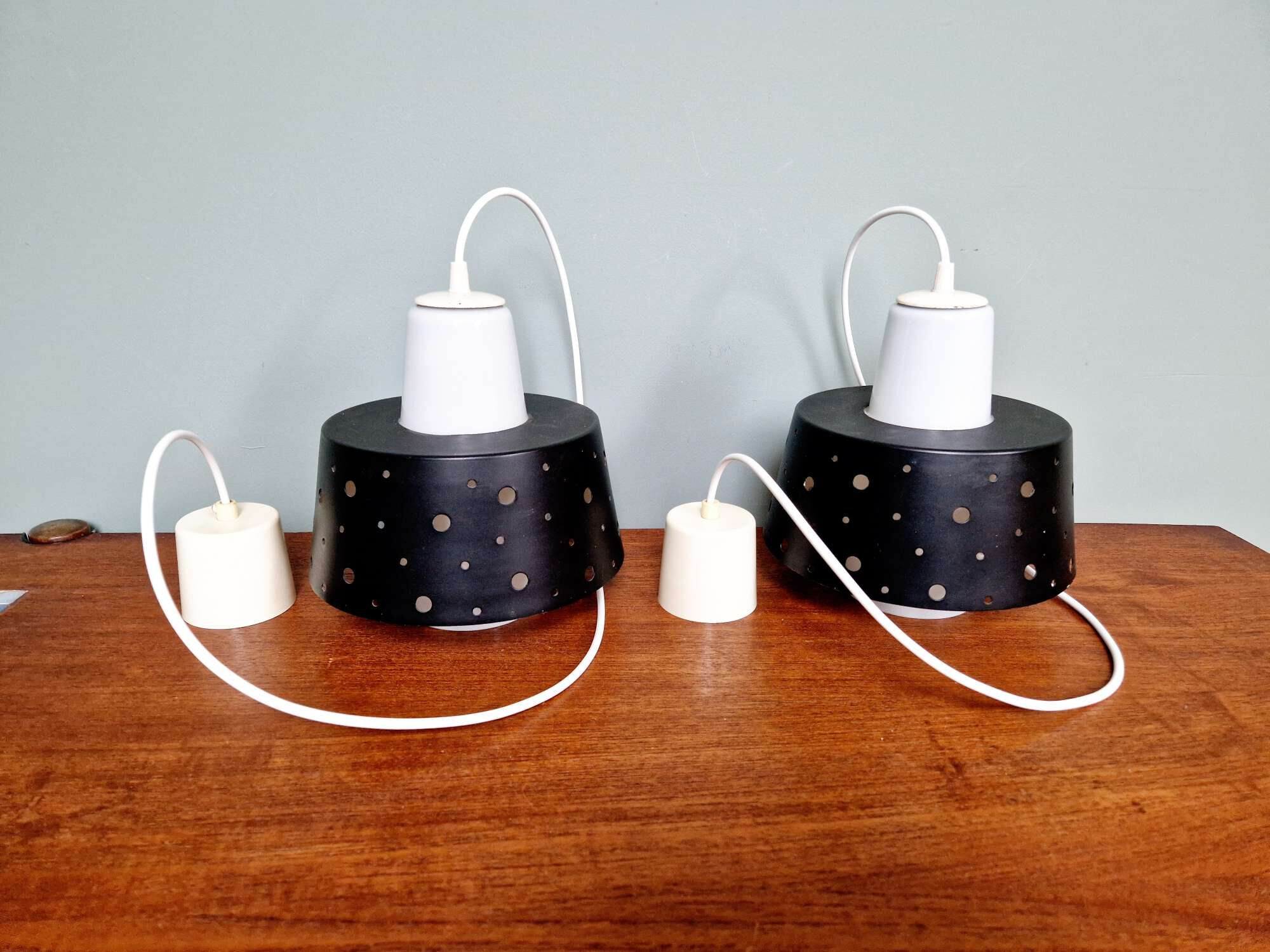 A pair of Scandinavian pendant lights in white opaline and black lacquered metal, 1960.