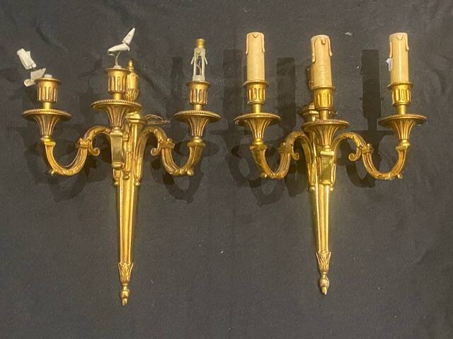 Pair of gilt bronze wall sconces with three lights in the Louis XVI style.