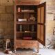 Antique walnut bonnetière with bevelled mirror.