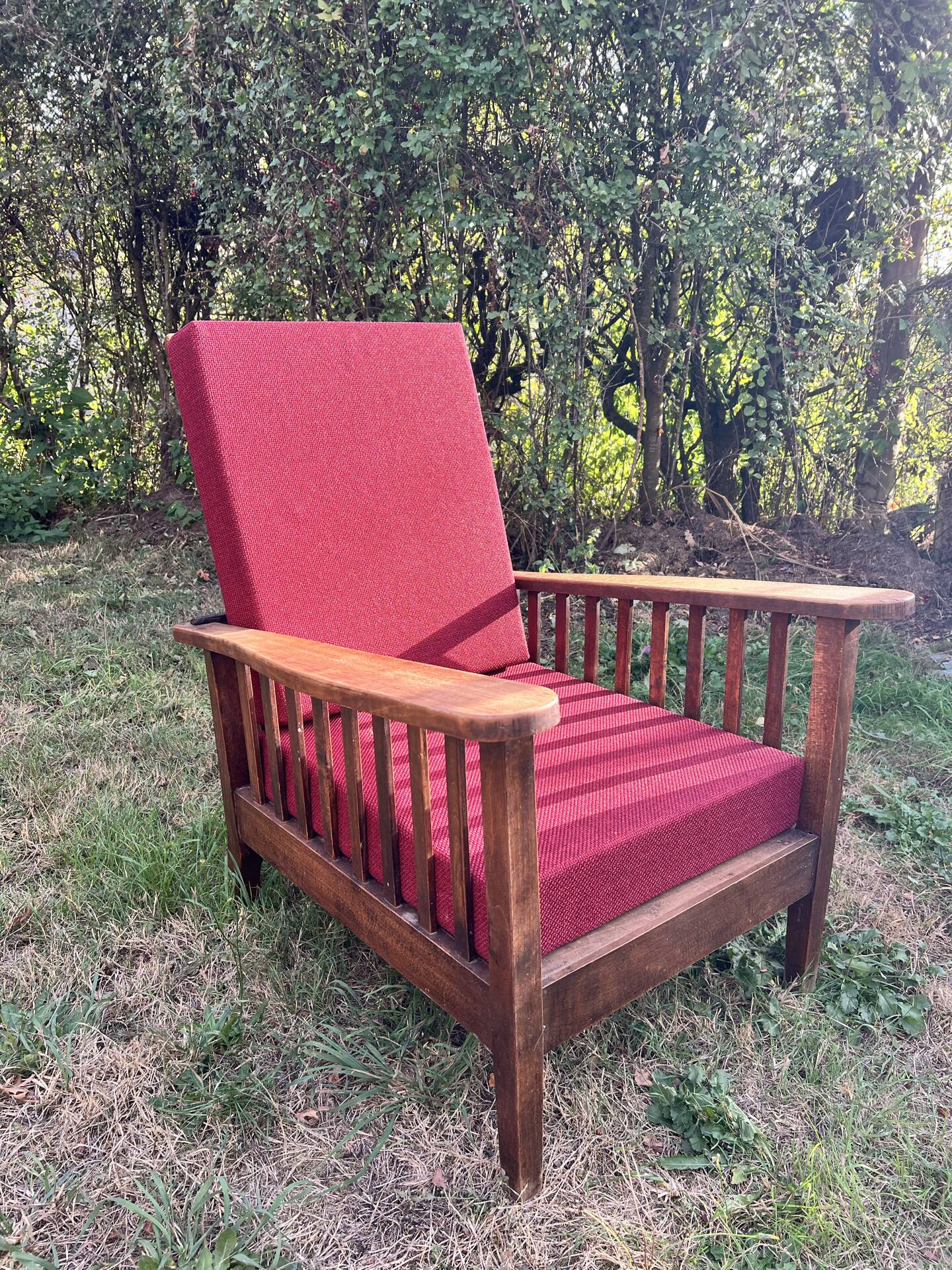 Morris chair with wooden frame and burgundy cushions.