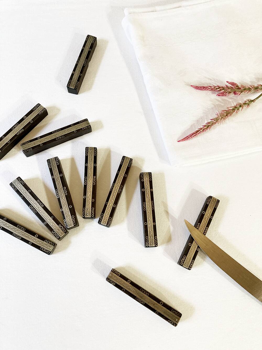 Set of 11 ebony wood knife rests with brass inlay