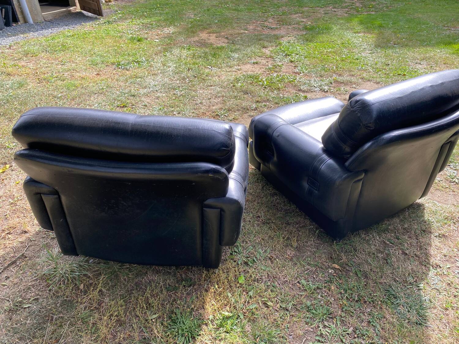 Pair of black imitation leather armchairs