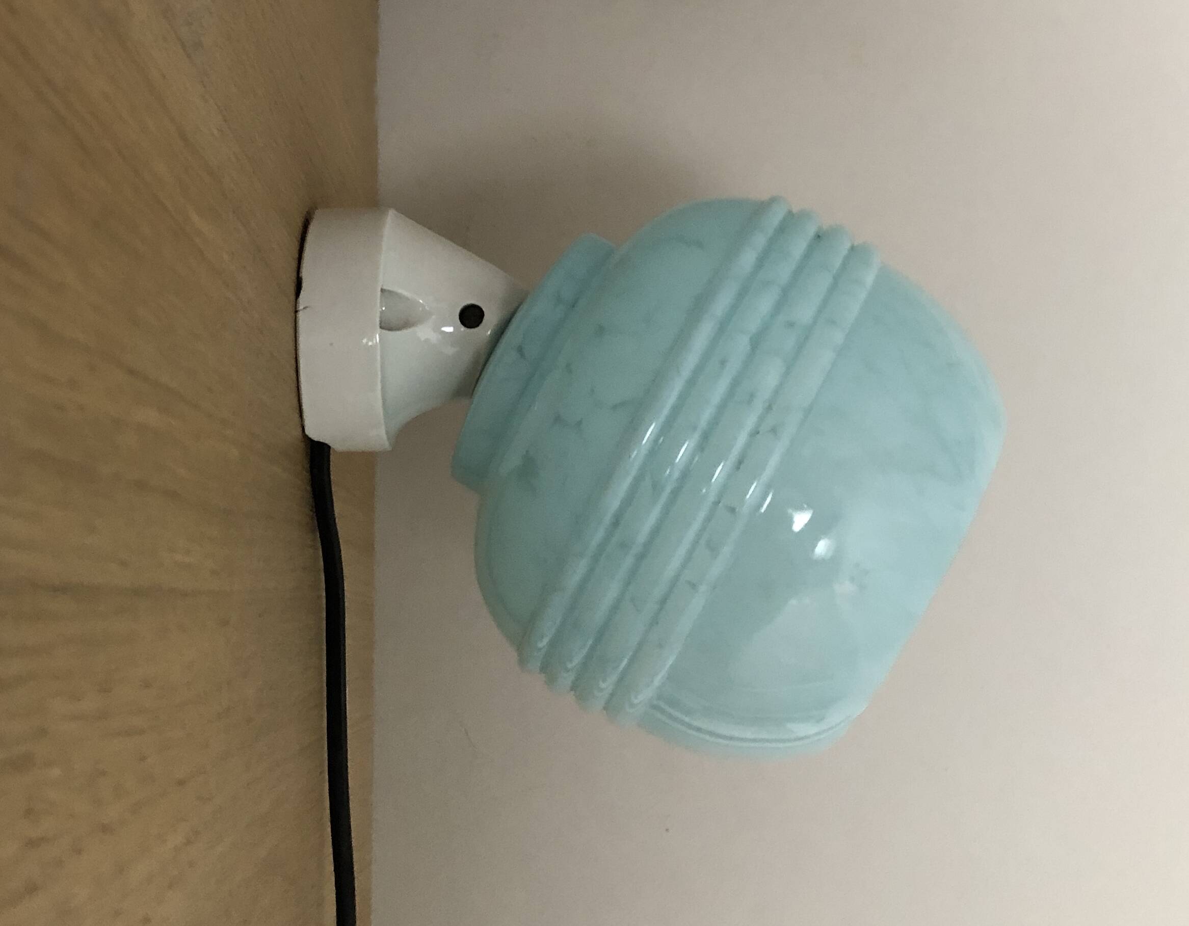 Wall light in ceramic with a light blue glass globe.